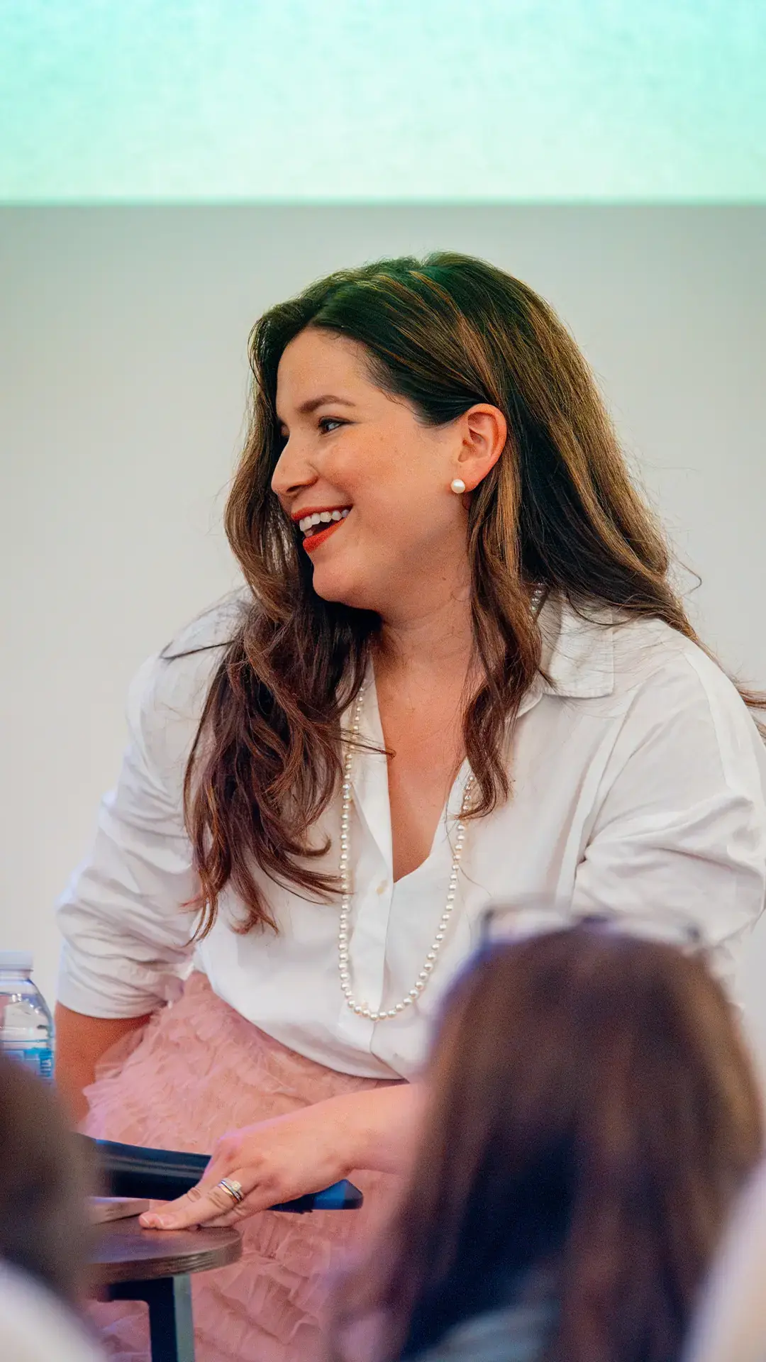 A woman smiling as she speaks at a Rise gathering