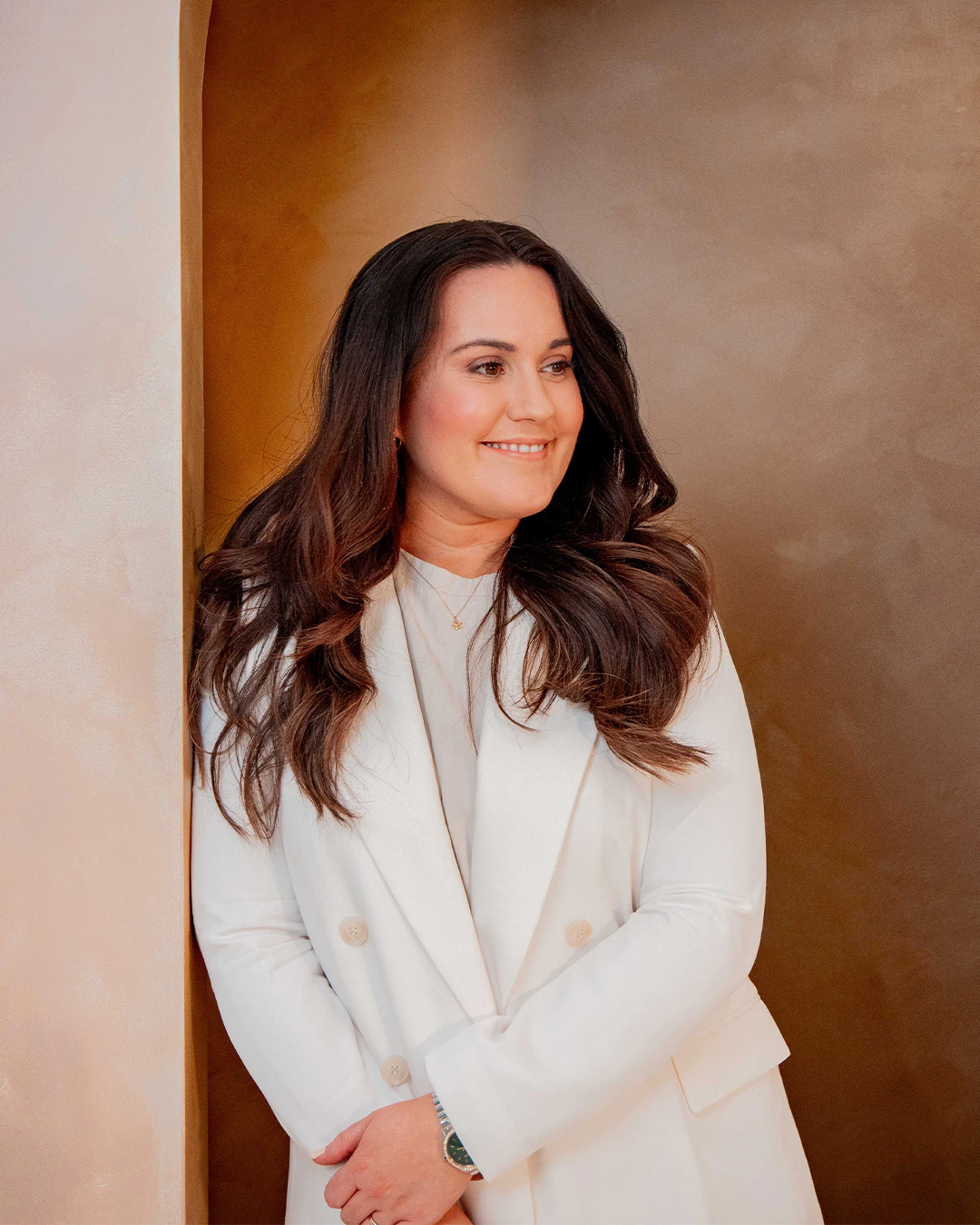 Beth Hobbs in a white suit, smiling